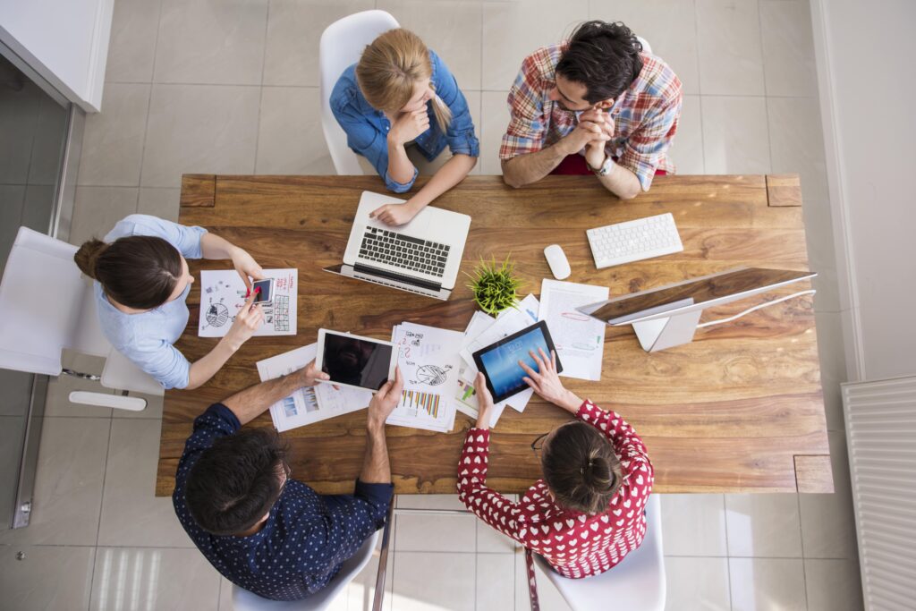 equipe-de-collegues-vue-de-dessus-travaillant-au-bureau-min